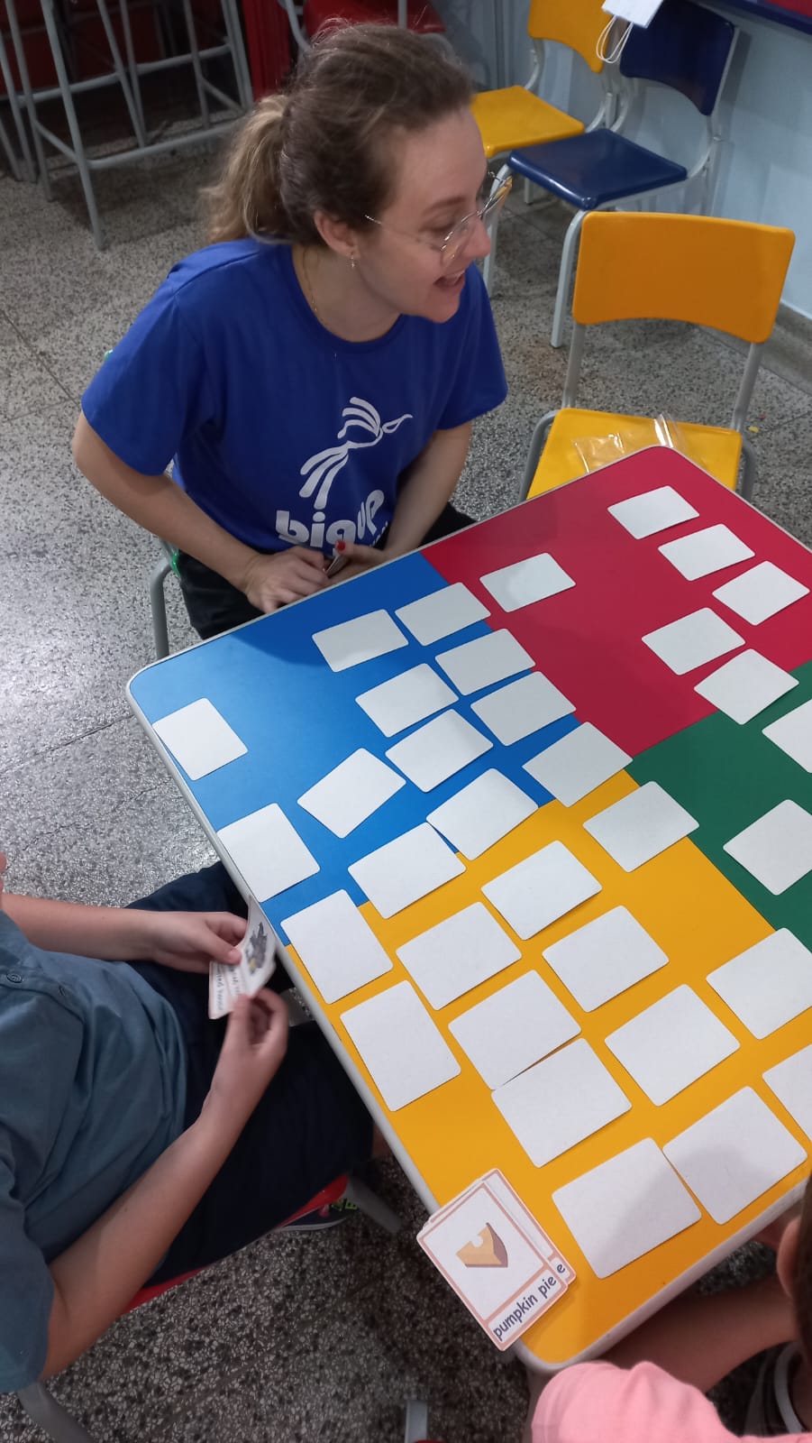 Professora da BigUp School conduzindo um jogo da memória em inglês com os alunos