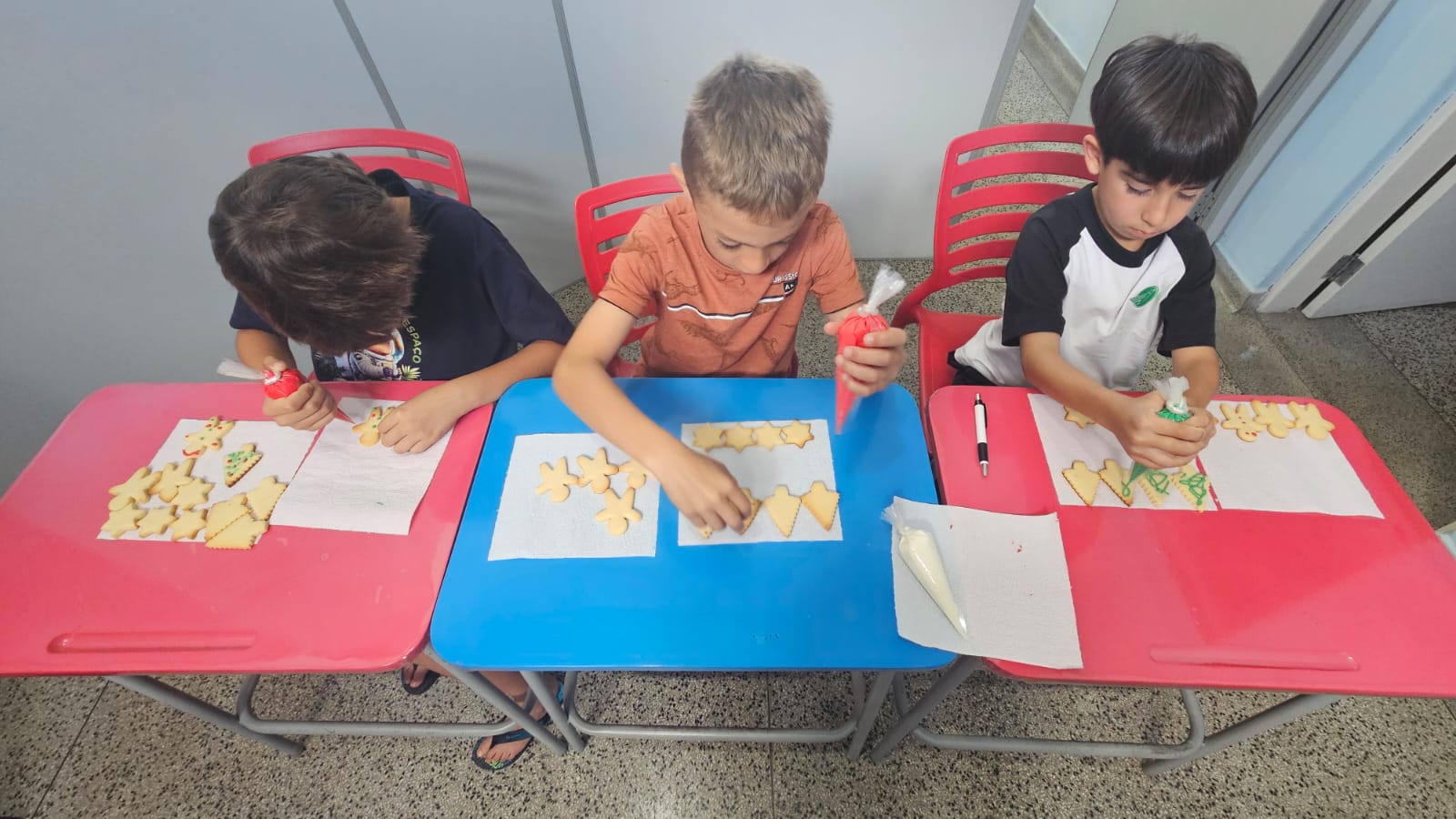 Alunos decorando biscoitos na aula de culinária em inglês